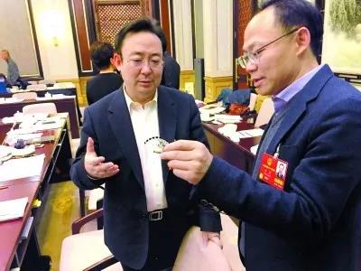 昨天,北京團小組會(huì )休息的間隙,程京代表(右)向夏林茂代表介紹基因芯片。張宇攝